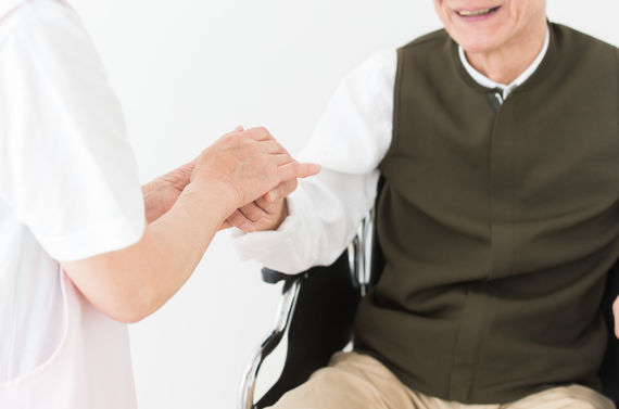 手を添える女性と車いすの男性